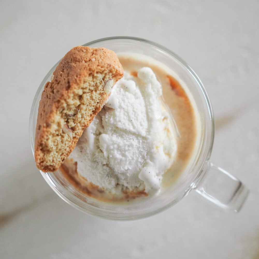 Overhead shot of a scoop of ice cream with espresso and an biscotti.