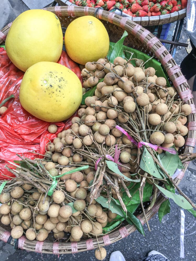 Overhead photo of longan fruit in a round basket.