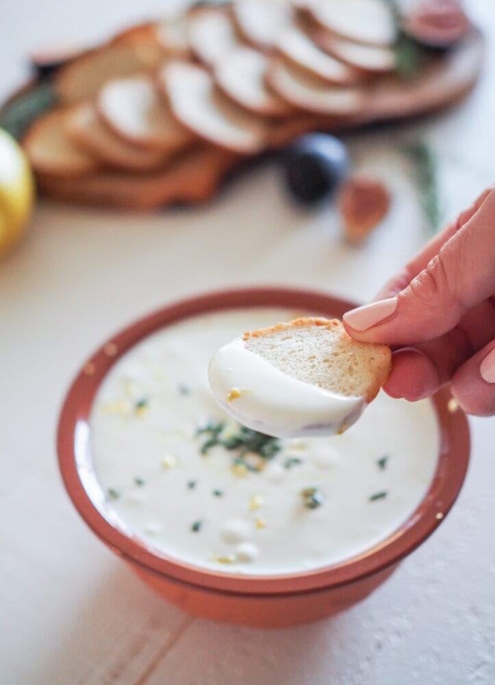 Cracker dipped in whipped ricotta dip.