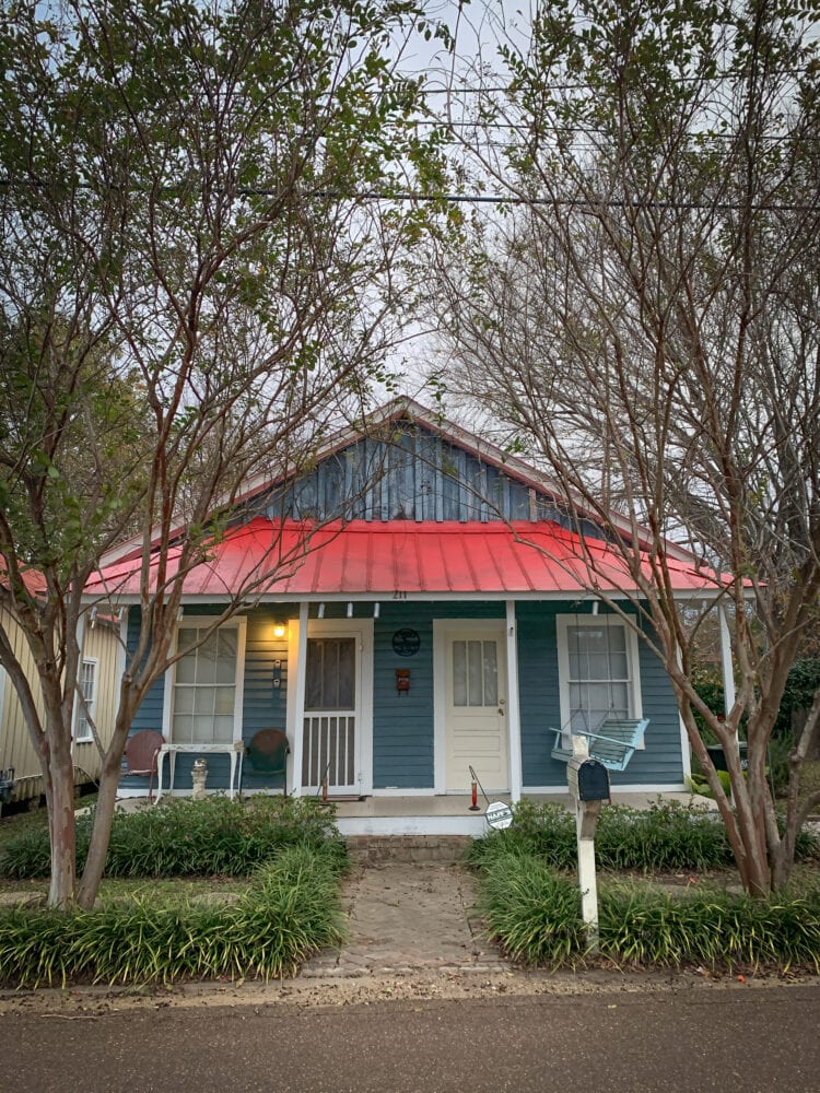 An old blue and red cottage in downtown Natchez.