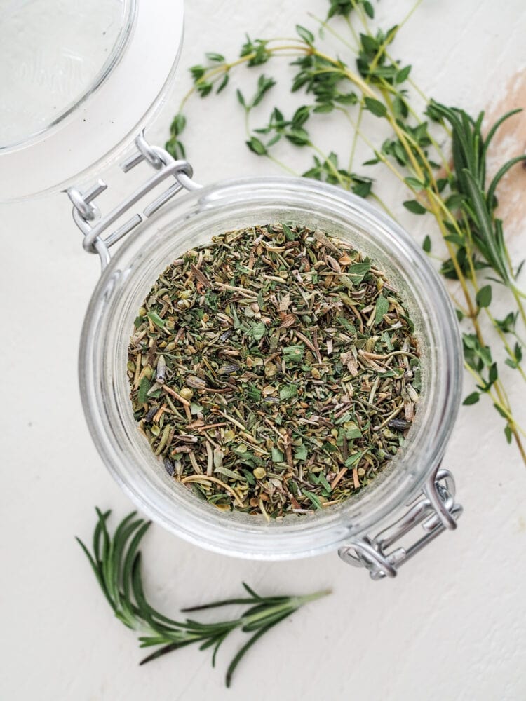 Overhead shot of a glass jar filled with herbs de Provence.
