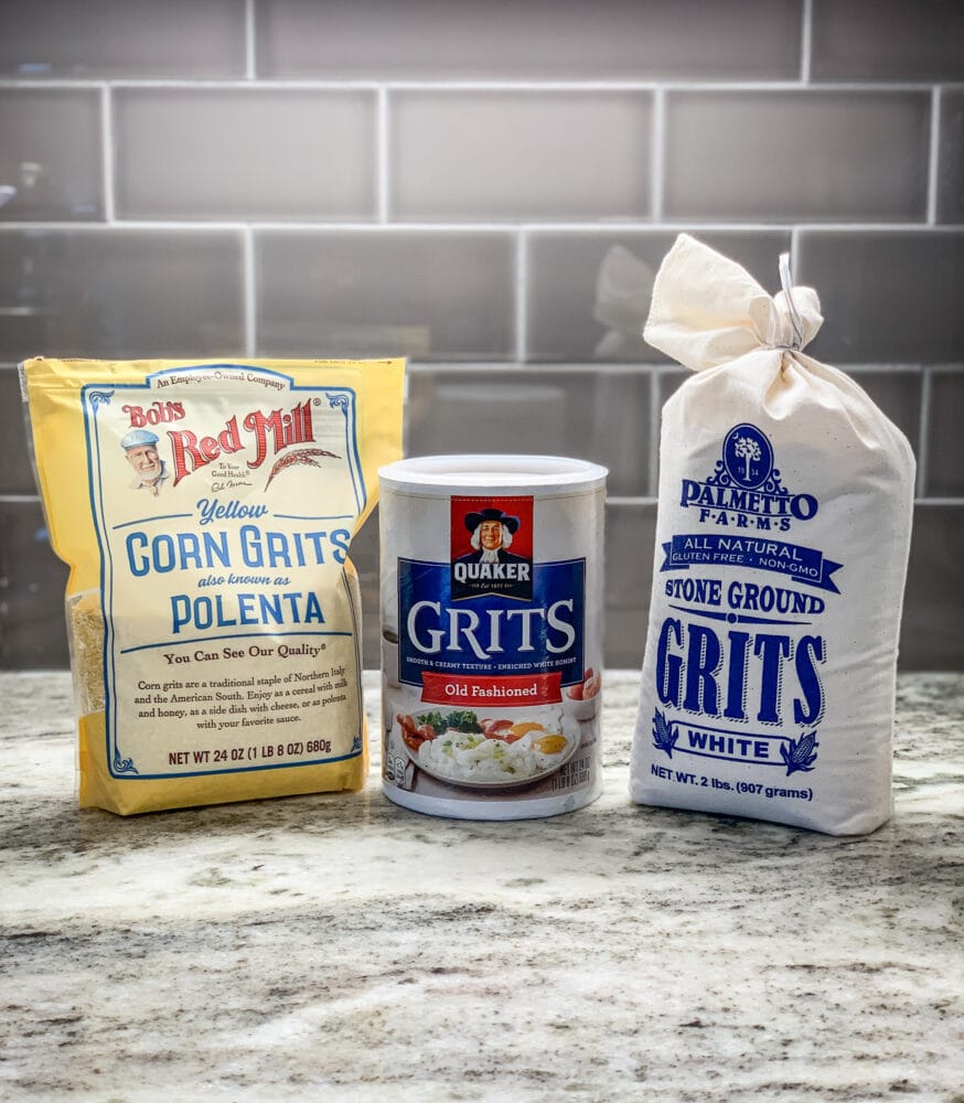 Three different styles and brands of grits on a countertop: Bob's Red Mill Yellow Corn Grits, Quaker Old Fashioned Grits, Palmetto Farms Stone Ground Grits