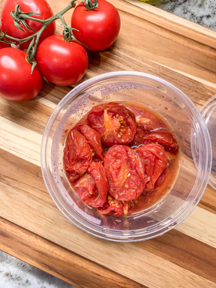 Making patatas bravas sauce ... Campari tomatoes, both raw and cooked, on a wood cutting board.