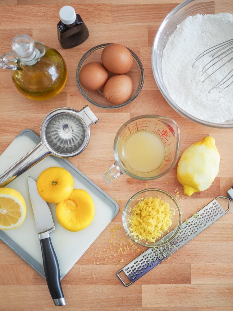 Overhead shot of zesting and juicing lemons into a separate bowl and measuring cup.