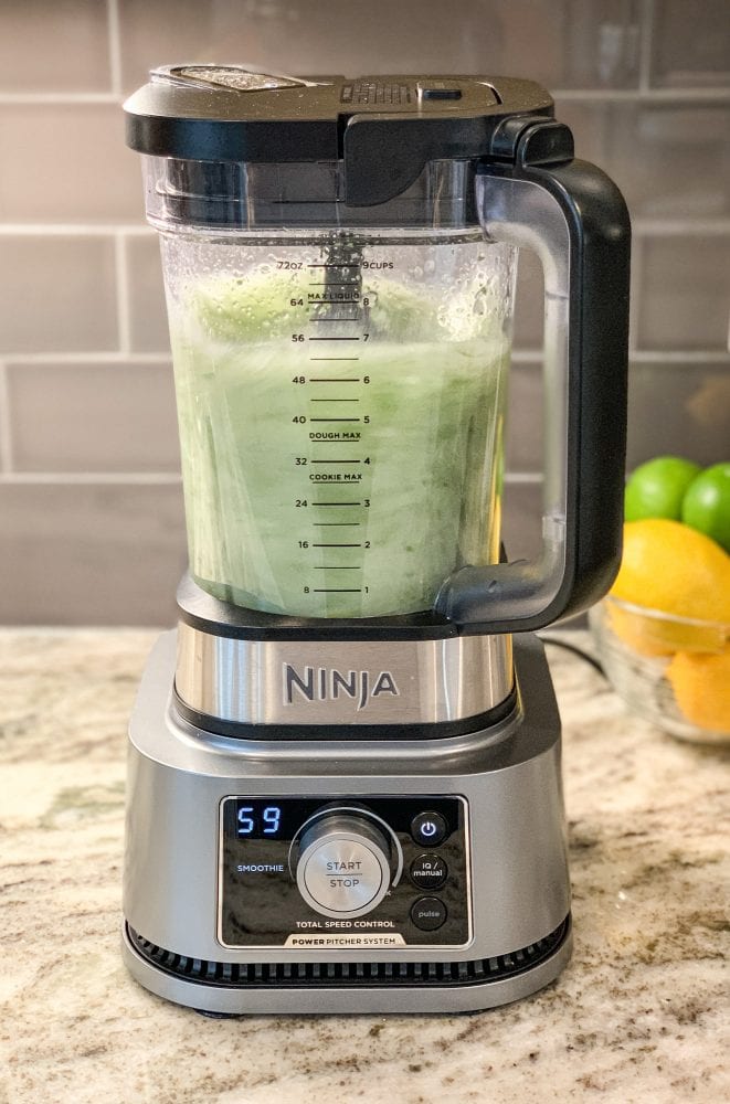 Side view of mint lemonade blending in a Ninja blender.