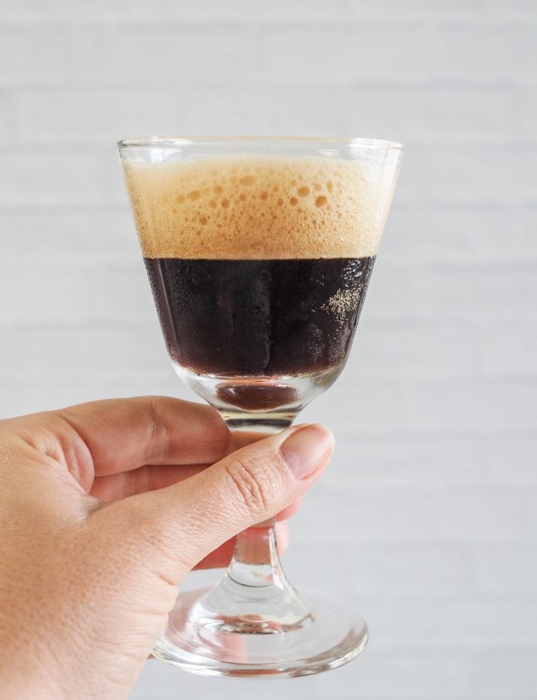 Holding up a shakerato to show the side view with the frothy crema on top.