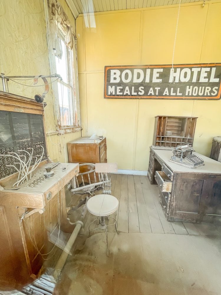Inside the Bodie Hotel with a telephone operator's desk, old type writer, and check in desk.