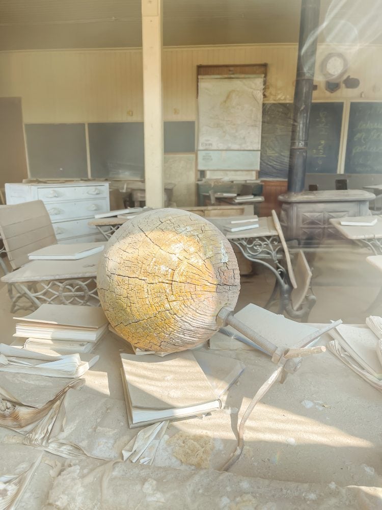 Another view inside the old schoolhouse in Bodie ghost town, showing an old globe that has had the maps deteriorated away from sun exposure.