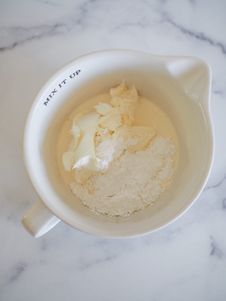 Mixing bowl with whipping cream, mascarpone, and confectioners sugar before blending.