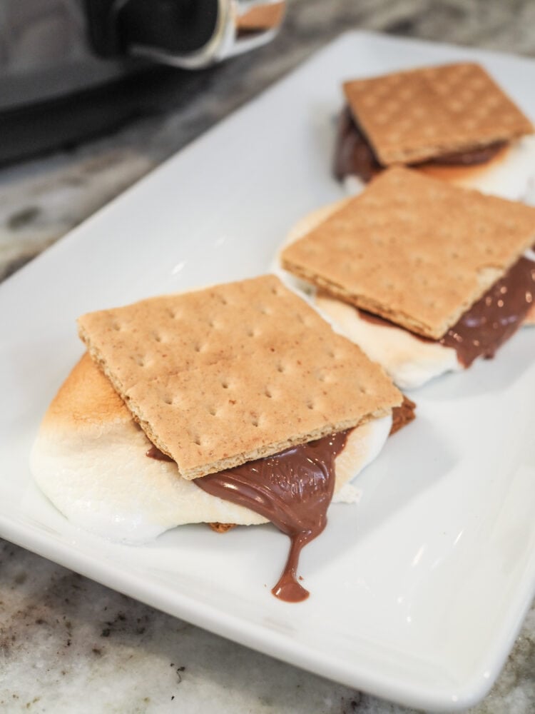 Close up of an air fryer smore, marshmallow and chocolate melting out over the sides.