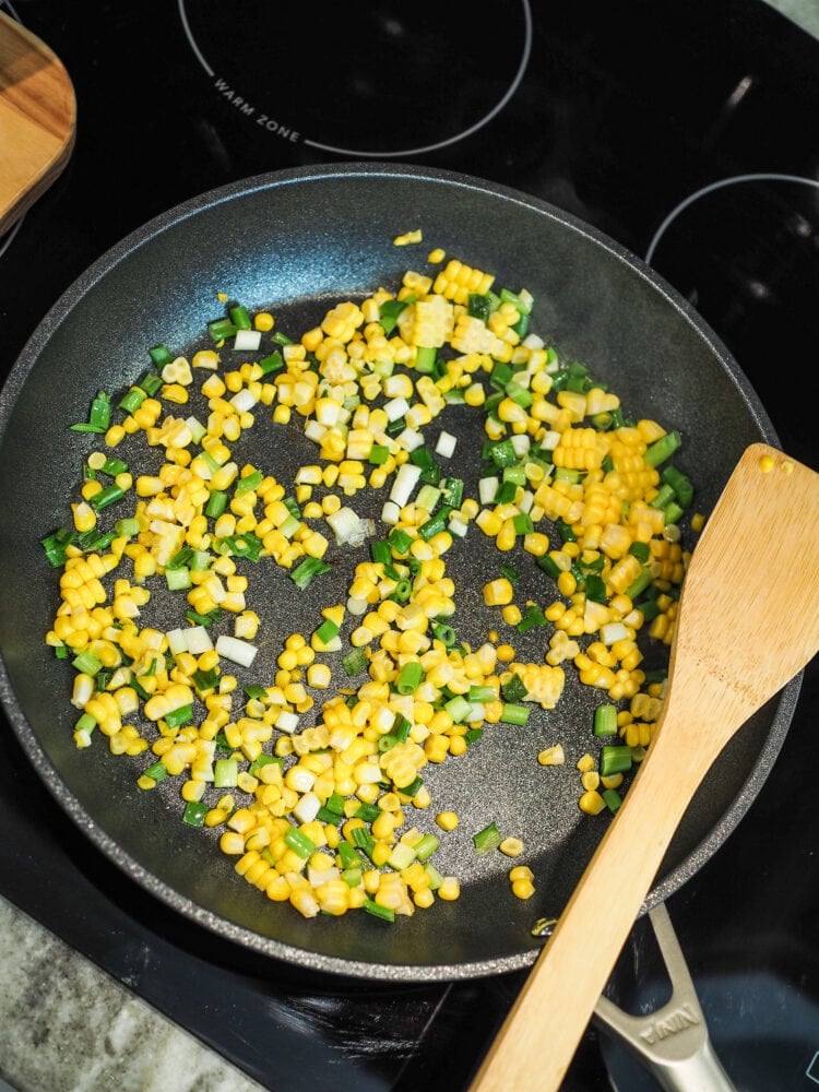 Corn and green onions in saute pan.