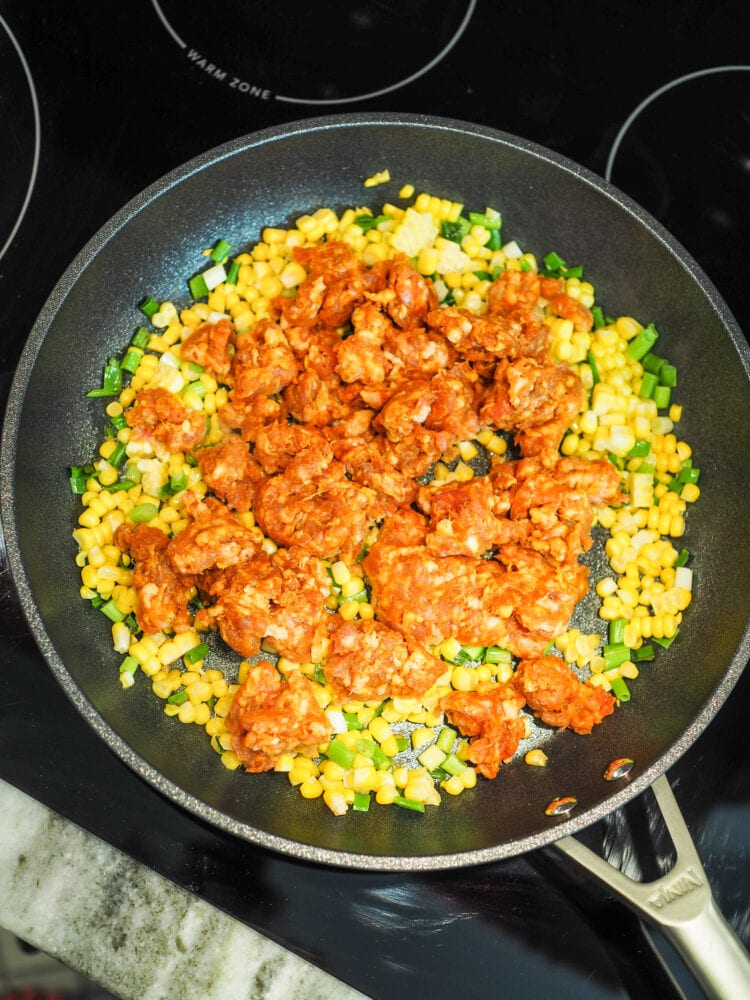 Chorizo corn and onions inside saute pan.