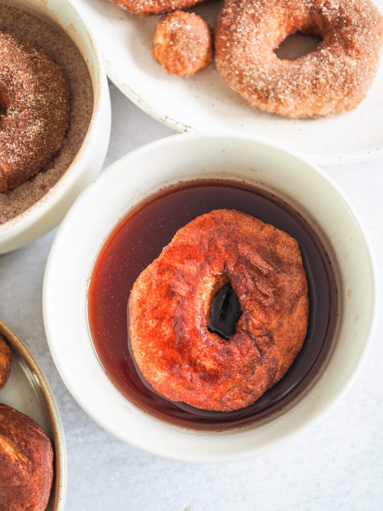 Close up of air fried donut in mulling spices syrup.