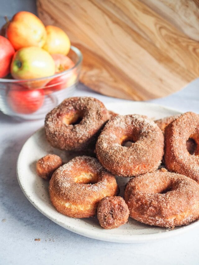Air fried apple cider donuts with bowl of apples in background