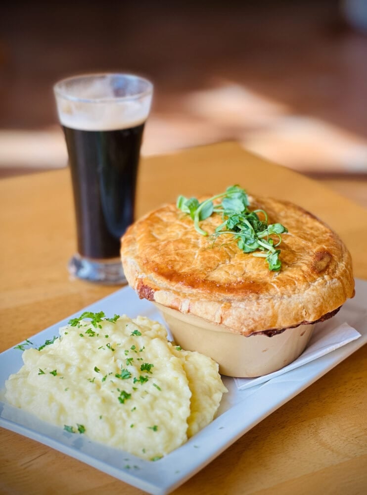 Steak and ale pie with a side of potatoes and half pint of Guinness.