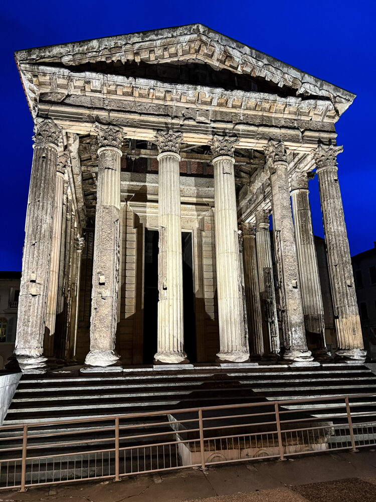 Temple of Augustus & Livia lit up at night with a sapphire colored sky in the background. Seen in Vienne during a Viking River Cruise in France.