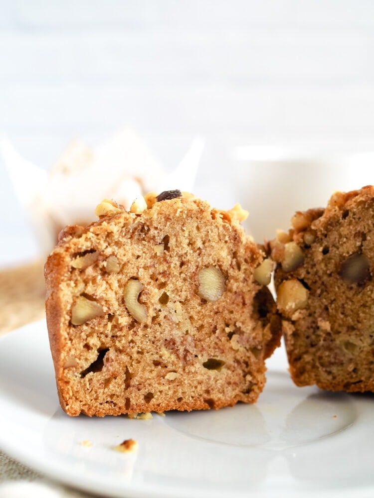 A banana nut muffin sliced in half showing the delicious looking dense texture of the muffin.