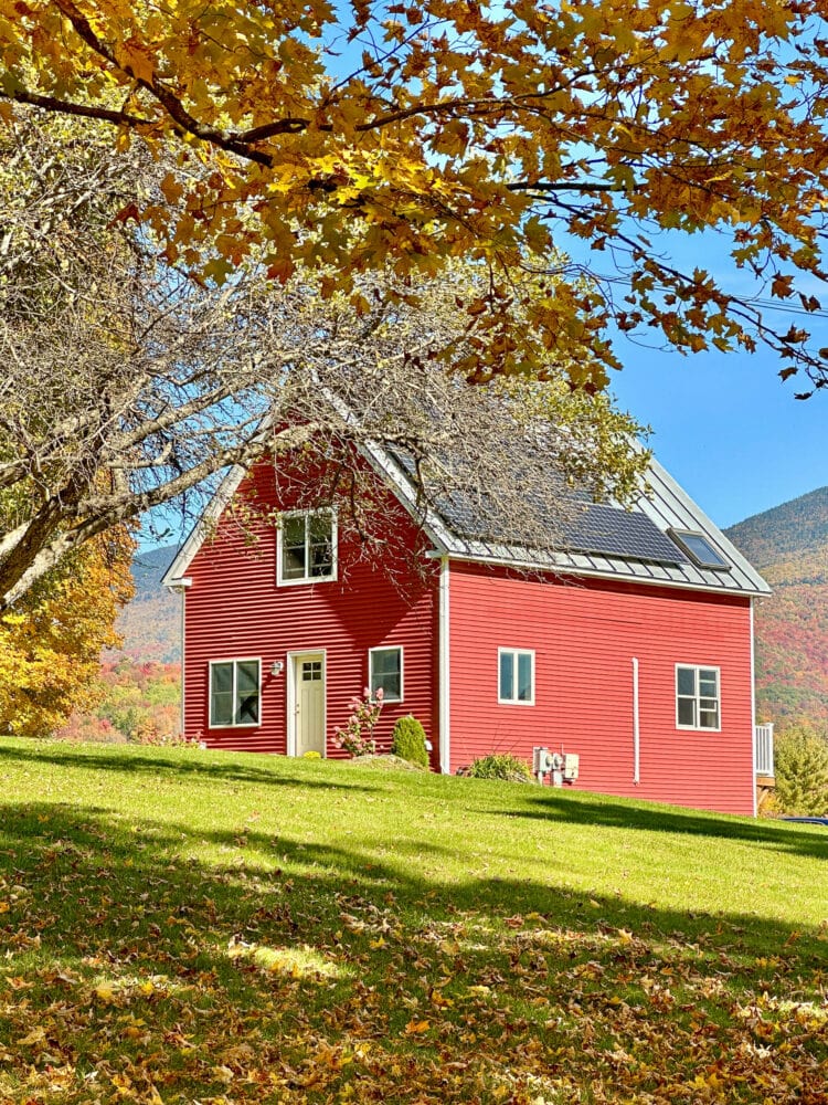 Scenic fall foliage and red house in Vermont.