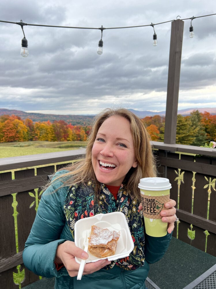 Rachelle sipping coffee and getting ready to enjoy an apple strudel outside Trapp Family Lodge bakery.
