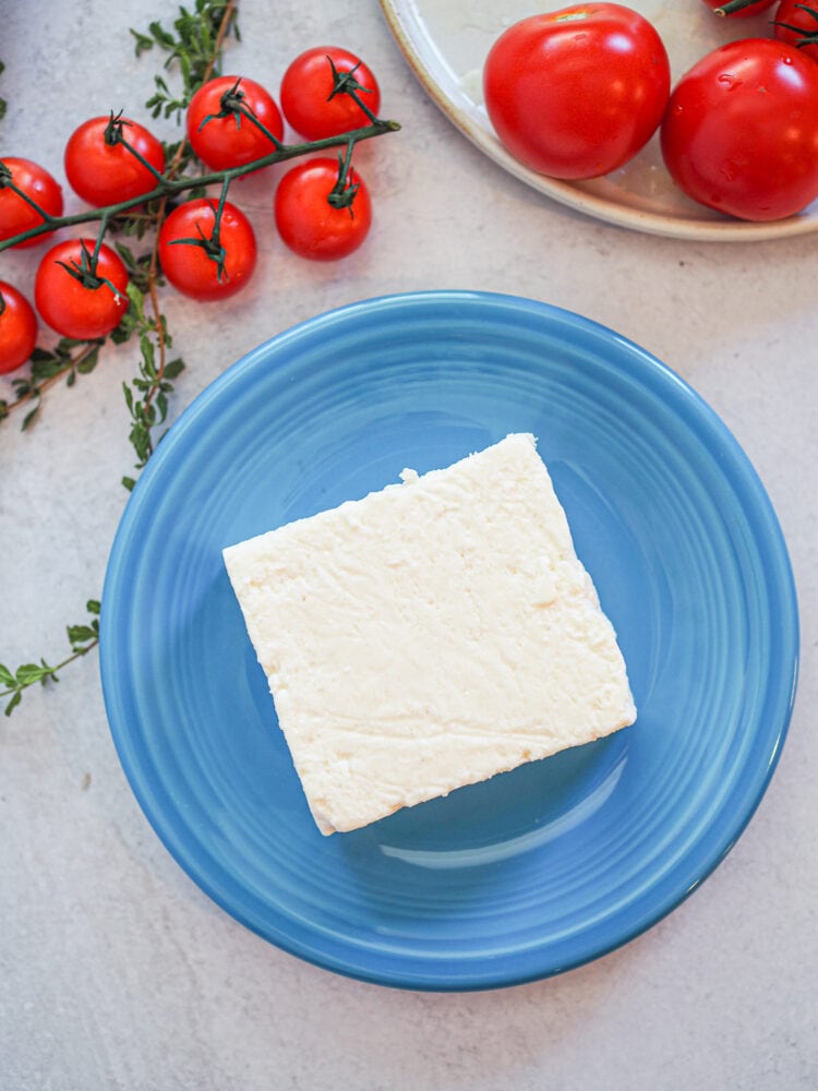 Whole block of feta cheese on a blue plate