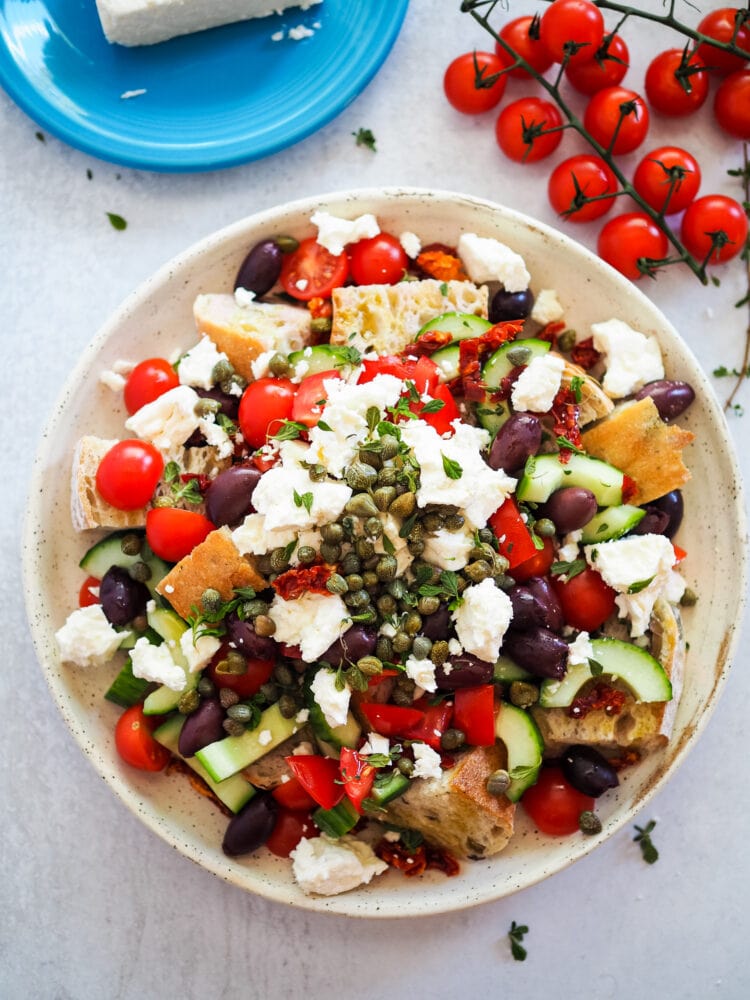 Overhead look at a dakos salad on a large serving plate.