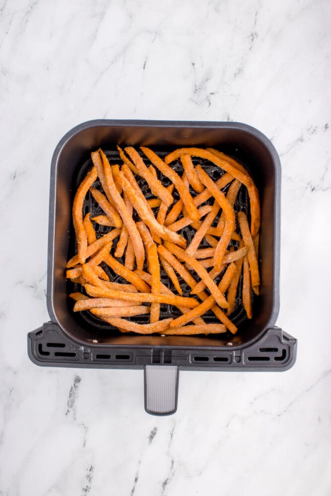 frozen sweet potato french fries in an air fryer basket
