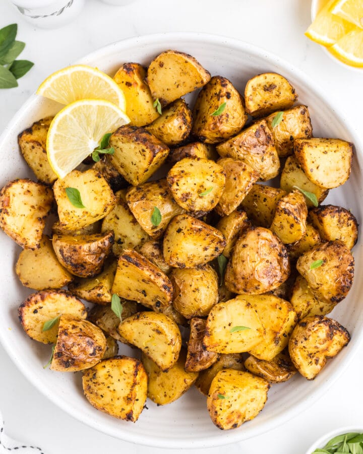 Close up of white bowl filled with air fryer greek lemon potatoes