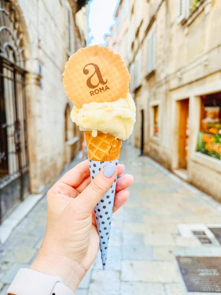 Rachelle holding up a small cone of gelato in Croatia.