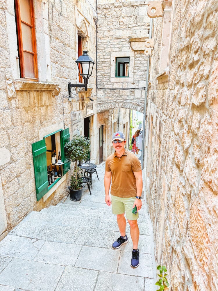 Pete standing in an ancient stone alleyway in Korčula, Croatia.