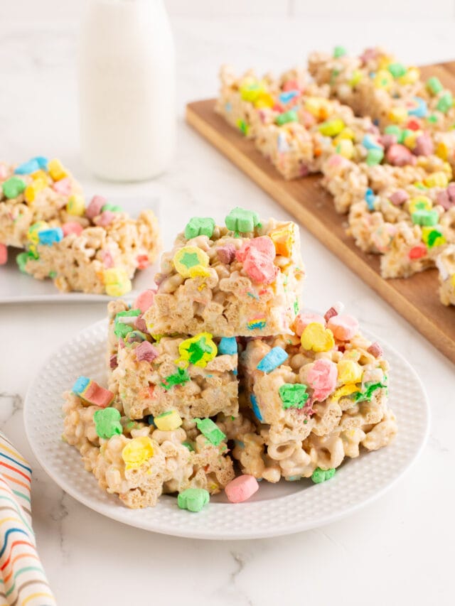 Lucky Charms Rice Krispie treats stacked on a white plate