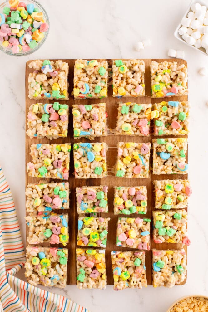Lucy charms rice krispie treats on a cutting board cut into 24 squares.