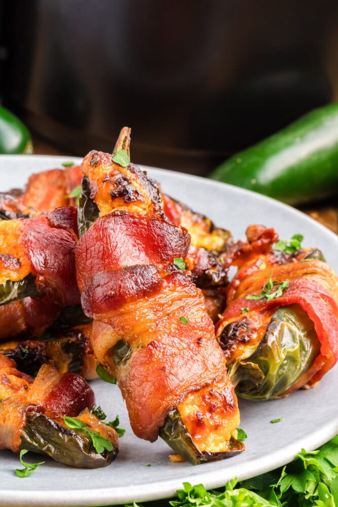 Close up of bacon wrapped jalapeno popper showing crispy bacon, carmelized cheese, and blistered jalapenos.