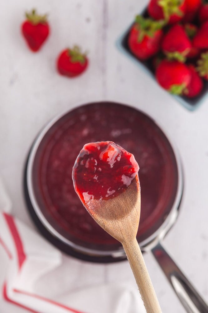wooden spoon dipped in strawberry sauce