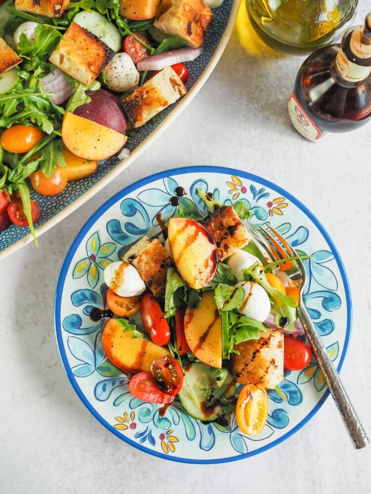 small plate of peach panzanella salad with a fork