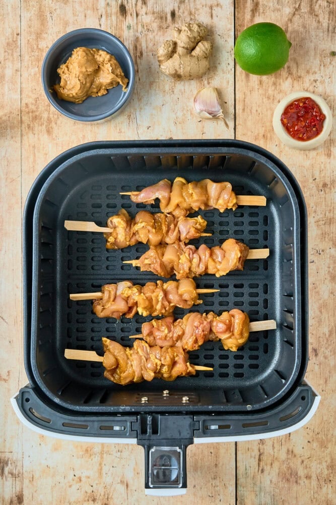 chicken skewers in air fryer basket before cooking