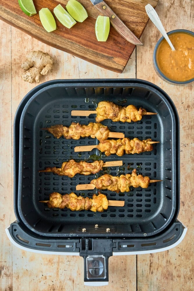 chicken on skewers in air fryer basket after cooking