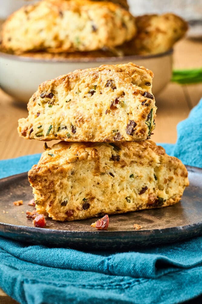 Two cheddar scones stacked on a plate