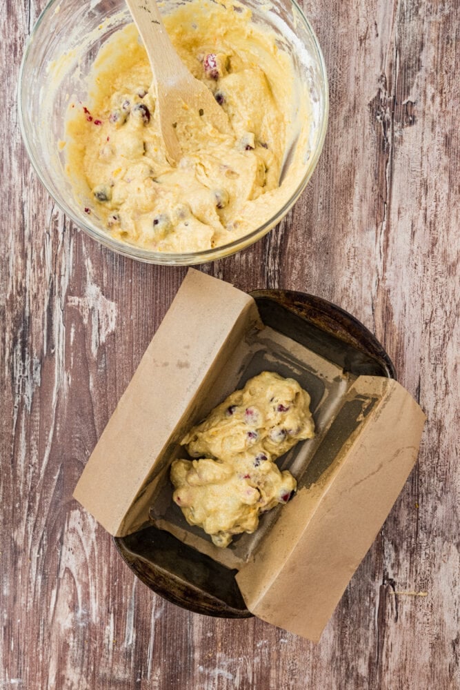 Adding cranberry loaf batter to a parchment lined bread pan