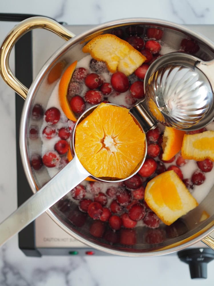 Squeezing orange with juicer