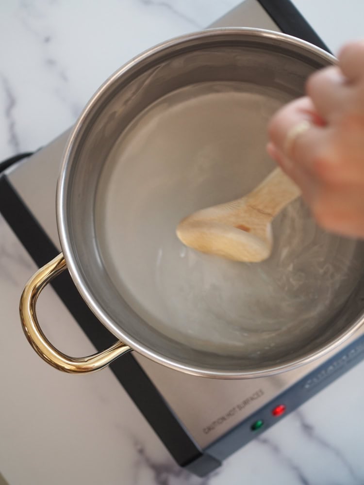 Dissolving sugar in hot water to make a simple syrup.