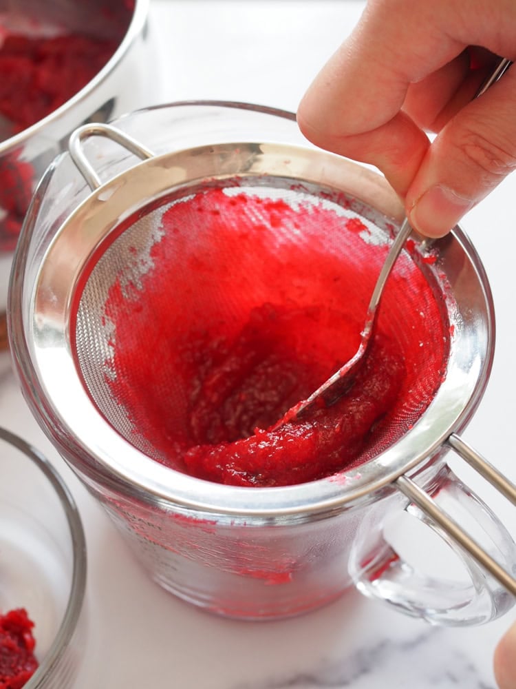 pressing cranberry sauce through sieve