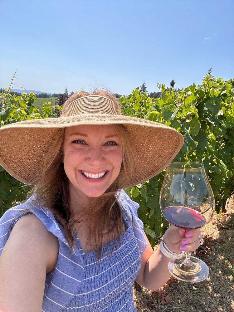 Rachelle holding a glass of red wine