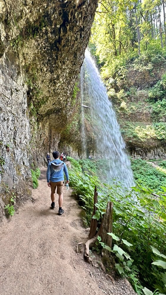 Pete hiking behind waterfall