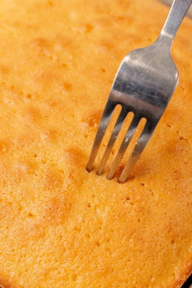 poking holes in cake with a fork