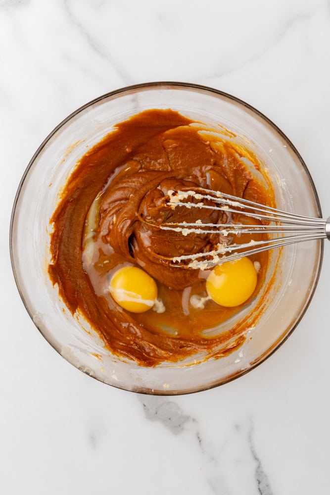 adding eggs and flour to gingerbread loaf mixture