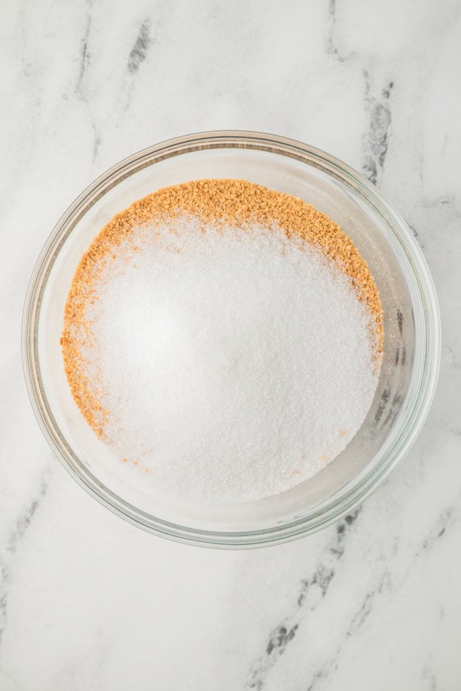 Dry ingredients for cheesecake crust in a glass bowl