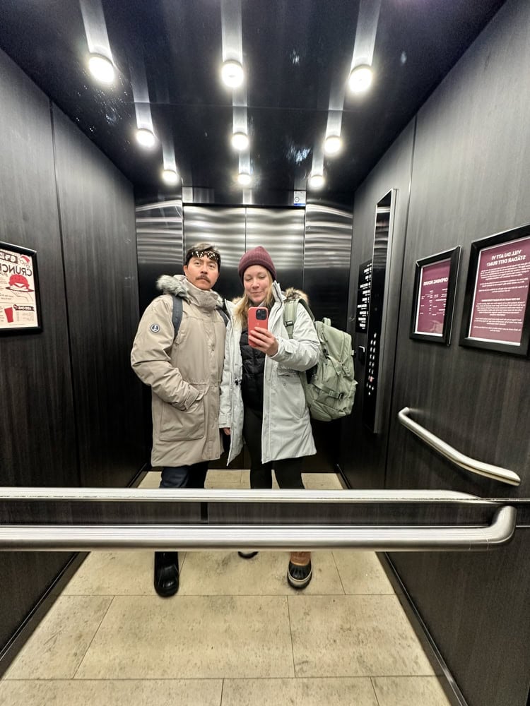 Rachelle and Pete in the elevator for a fit check, showing what was on their winter packing list and dressed for cold weather.