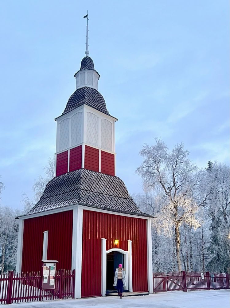 Rachelle by a red building with a snowy white backdrop
