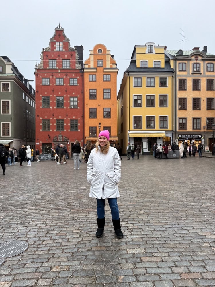 Rachelle in Stockholm wearing a pink cashmere beanie, jeans, bearpaw boots, and a white parka