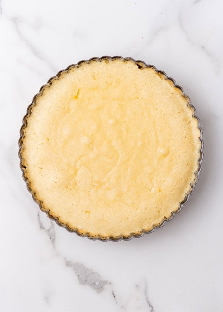 finished baked tart crust before the almond topping is added. it looks light in color